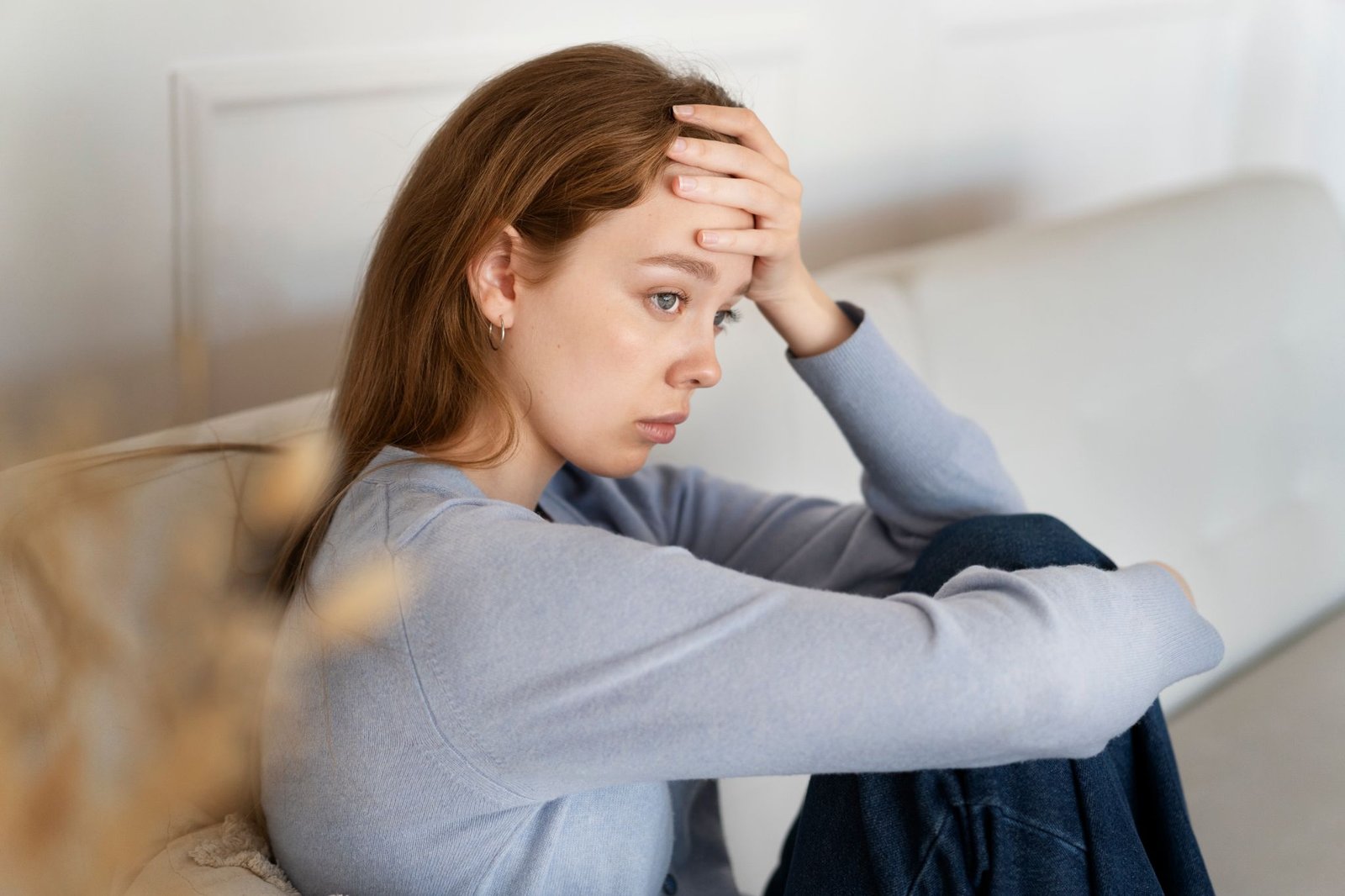 anxious woman sitting couch side view