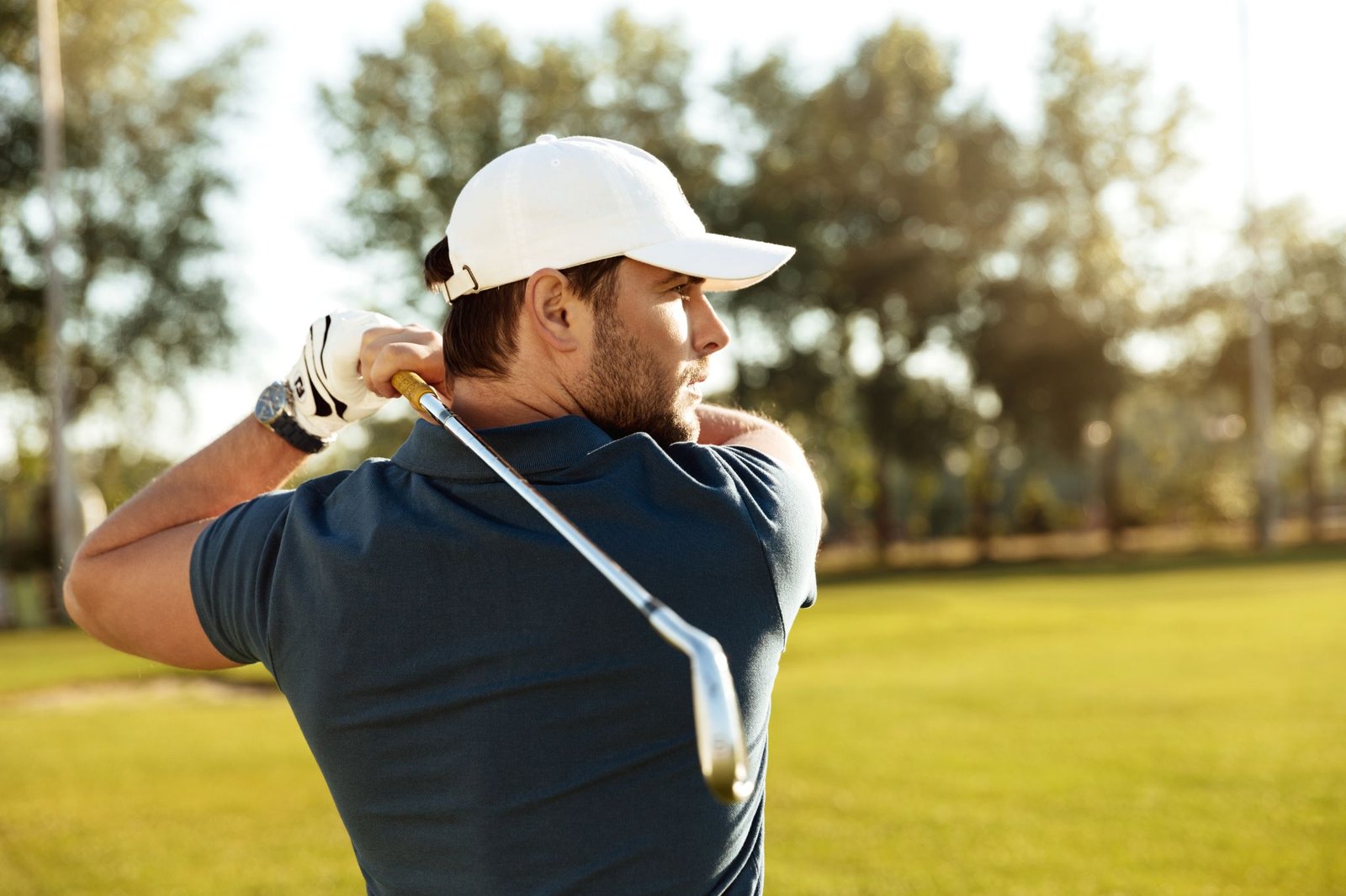 close up young concentrated man shooting golf ball